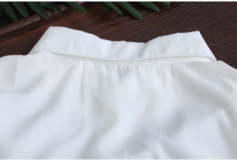 Camicia da donna bianca a tinta unita, media lunghezza, per esportazione transfrontaliera, estiva, casual, ampia, davanti corta, dietro lunga, ideale per il sole._voghion.com